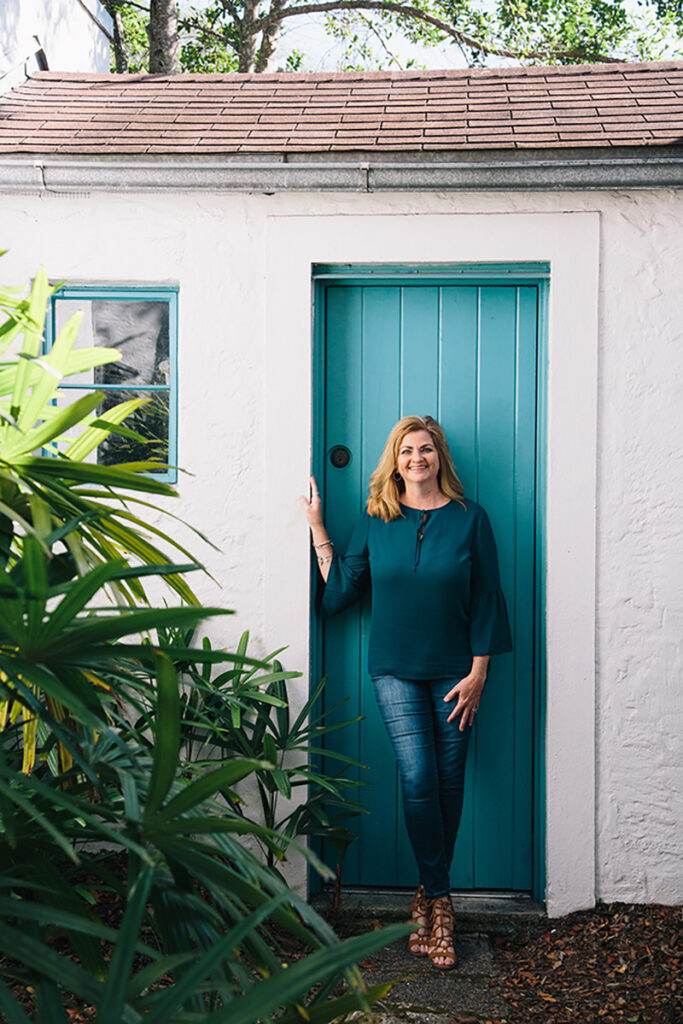 shelley jean standing in front of teal colored door